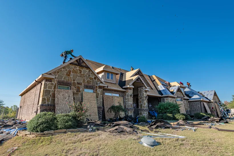 Crew installing a new roof on a large brick home